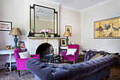 Grau gepolstertes Sofa mit rosa Sesseln im Wohnzimmer eines Hauses in Hackney, London, England, UK