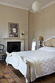 Weißes Doppelbett mit originalem Kamin und orientalischem Fotodruck in einem Haus in Hackney London England UK