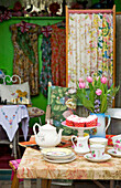 Rosafarbene Tulpen und Muffins mit Teekanne und Tassen in Brighton, Sussex, England, UK