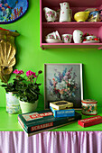 Houseplants and crockery with board games on bright green worktop brighton Sussex England UK