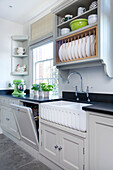 Tellergestell und Butler-Spüle in einer Küche in Woodchurch, Kent, England UK