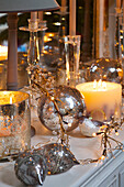 Silver baubles with lit candles on white sideboard in Faversham home Kent England UK