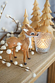 Deer ornament with lit candle on wooden sideboard in Faversham home Kent England UK