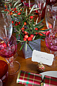 Pink glassware and Christmas flowers with handwritten nameplace on dining table in Faversham home Kent England UK