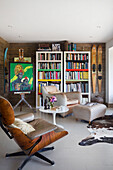 Armchairs and bookcase with artwork on easel in Rye East Sussex UK