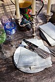 Messer und Servietten auf Tellern mit silbernen Kerzenleuchtern und Weingläsern Rye East Sussex UK