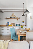 Light blue chair at table with pendants in Dartmouth kitchen Devon UK