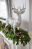 Silver reindeer and garland with pinecones in London home UK
