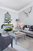 Winter flowers and hues of grey in living room of London home UK