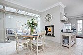 Winter lilies and bench seat in white open plan kitchen London UK