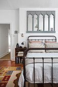 Gothic mirror above metal framed bed Southsea UK
