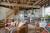 Tan leather sofa kitchen and dining table in open plan 'meal floor' of Grade ll listed windmill conversion Kent UK