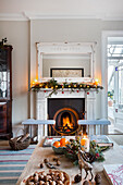 Beleuchtetes Feuer und Glasvitrine mit Weihnachtsdekoration im Warehorne Pfarrhaus in Kent UK