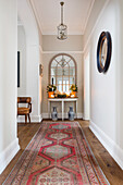 Vintage rug and convex mirror in wide hallway of 1820s rectory Warehorne Kent UK