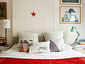 Animal motifs on furnishings on bed with red blanket in London home England UK