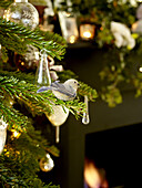 Bird ornament and glass baubles on Christmas tree in London home England UK