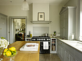 Rezeptbuch auf Marmorschneidebrett in grau gestrichener Küche eines Landhauses in East Sussex, England, UK