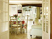 Esstisch mit geblümter Tischdecke und Sessel in offenem Haus in Nottinghamshire, England, UK