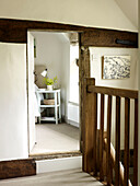 Wooden banister with view into bedroom of timber-framed West Sussex farmhouse, England, UK