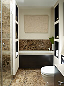 Brown tiled bathroom with frieze and shelving units in London townhouse, UK