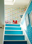 Letter 'M' at top of brightly painted staircase in London family home, UK
