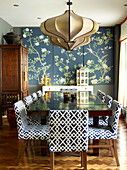 Oriental panels in dining room with upholstered chairs in London townhouse apartment, UK