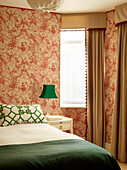 Green accents in bedroom with vintage wallpaper, London townhouse, UK