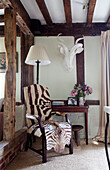 Animal print covered chair in timber framed cottage, Kent England, UK