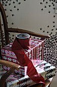 Burgundy ribbon and Christmas gifts on chair in London home UK