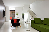 Limonengrünes Sofa und kleiner schwarzer Stuhl in offenem Interieur einer modernen Londoner Wohnung, England, UK
