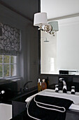 Gefaltetes schwarzes Handtuch auf Waschbecken in Londoner Wohnung UK