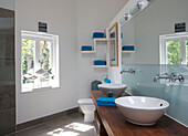 Double basins in sunlit Cambridgeshire bathroom with fish statues on windowsill UK