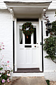 Weihnachtskranz an der weißen Eingangstür eines Hauses in Kent, England, Vereinigtes Königreich