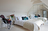 Double bed with mirrored wardrobe in attic conversion of Sussex home UK