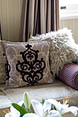 Black patterned and ostrich feathered cushions on sofa