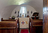 Wooden pews in small church with carved ceiling Scotland UK
