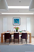 Brown dining chairs at table in extension of London home, UK
