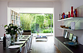 Assorted vases on shelving in dining area of open plan contemporary London home, England, UK