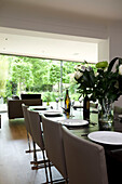 Esstisch mit Blumenarrangement in einem modernen Haus in London, England, UK