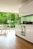 Kochtopf auf Kochfeld in weißer, offener Einbauküche eines modernen Hauses in London, England, Vereinigtes Königreich