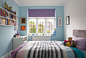 Childs room in pastel blue with lilac roller blind in London home, England, UK