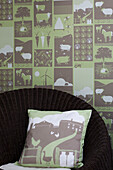 Moo! wallpaper panel with cushion above rattan chair in London bedroom UK