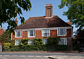 Brick exterior with tiled roof and chimney of East Sussex home, England, UK