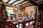 Christmas table with lit candles in timber framed Sussex home UK