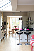 Black bar stools at breakfast bar of open plan London kitchen with skylight UK