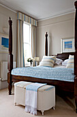Dark wood be with light blue quilt in London home UK