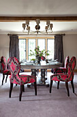 Pink embroidered chairs at dining table in Cotswold home UK