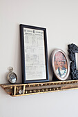 Framed pictures and vintage clock on gilt shelf in Berkshire home, England, UK