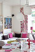 OPen plan dining and living room with pink furnishings in contemporary London home, UK