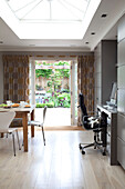 Office chair at desk and table in open plan extension of contemporary London home, UK